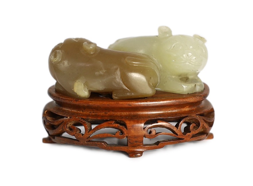 A Chinese pale celadon and brown jade group of two cats, 19th century, 5.1cm, wood stand, tiny chips